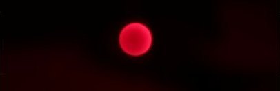 A dark frame with a small pink LED dot near the center.